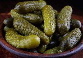 Juicy crispy cucumbers in a clay cup. Salted cucumbers.