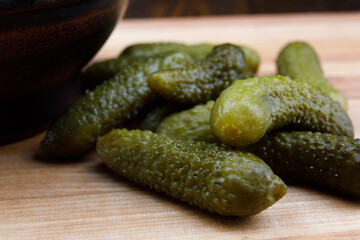 Juicy crispy pickled cucumbers on a wooden cutting board. Salted cucumbers.