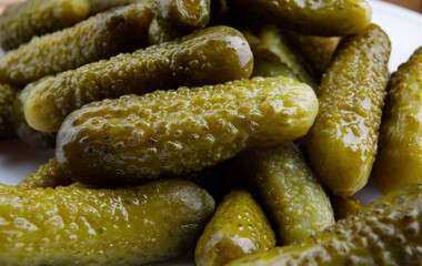 Crispy pickled cucumbers on a white plate.