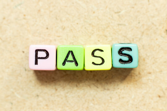 Color alphabet letter block in word pass on wood background