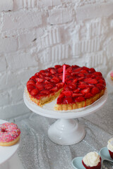 Delicious strawberry tart topped with jelly with one pink candle. Birthday cake