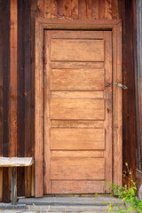 Old Russian door with peeling paint in the wooden wall of the house. Vertical image.