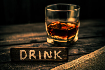 Glass of brandy with a piece of canvas and the wooden plank on it is an inscription 