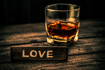 Glass of brandy with the wooden plank on it is an inscription 