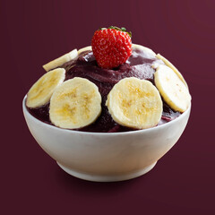 Açai, Brazilian frozen açai berry ice cream bowl with banana slices and strawberry. Isolated on purple background