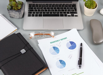 Modern office grey desk with reports and modern gadgets close up