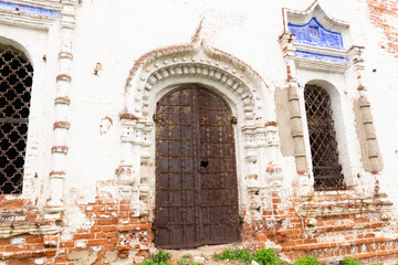 Fototapeta na wymiar old rusty church door on ancient wall with decoration