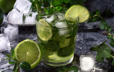 Fototapeta premium Cool summer drink with lime. Drink on the rocks. A cold drink with ice and lime.