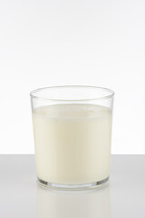Vaso de yogur líquido sobre fondo blanco