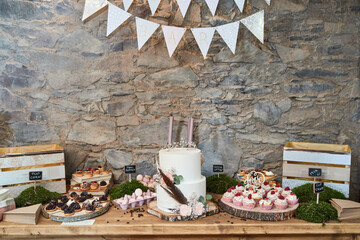Wedding sweet bar with white cake, cupcakes, macrons