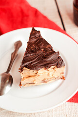 Dark chocolate cake with Coffee slice with chocolate buttercream frosting on a white plate.Copy space