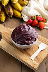 Açai, Brazilian frozen açai berry ice cream bowl. with fruits on wooden background. Summer menu front view