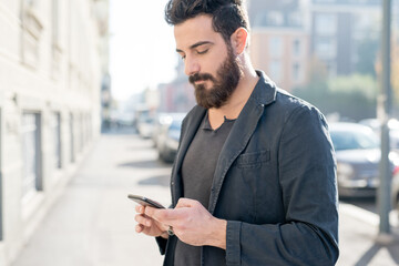young man bearded outdoor using smartphone