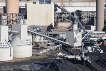 An aerial view  taken from a helicopter of a coal and biomass power station in Britain. A coal transporter is digging from huge store piles.