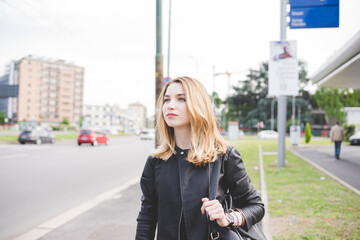 Fototapeta premium Young blonde woman walking outdoor confident and serene