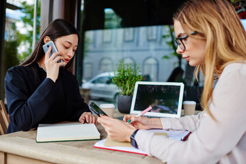 Pensive diverse colleagues working on terrace of cafe