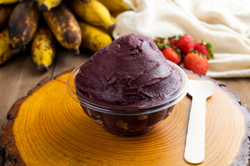 Açai, Brazilian frozen açai berry ice cream bowl with strawberries and bananas. with fruits on wooden background. Summer menu front view