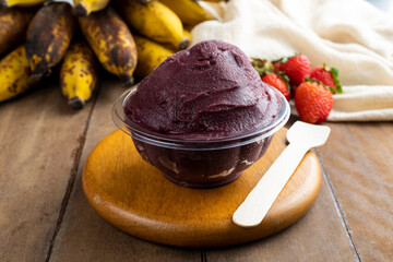 Açai, Brazilian frozen açai berry ice cream bowl with strawberries and bananas. with fruits on wooden background. Summer menu front view