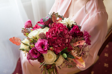 woman in pink dress holding a bouquet of different flowers