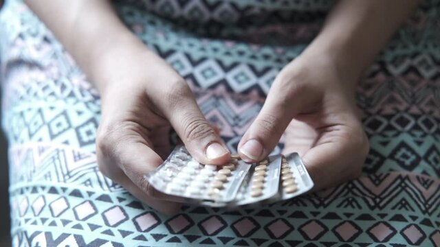 female hand golding birth control pills 