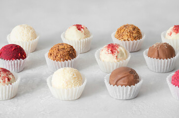 Homemade truffles on a white background. Candy or energy balls with chocolate, coconut, nuts, karkade and dried fruit. Healthy eat.