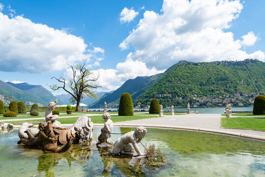 Statues in the fountain of the garden of the famous Villa Olmo (translation: Olmo's Villa), Como, Italy. The gardens are located on the shore of Lake Como. Blue sky and white clouds on the background