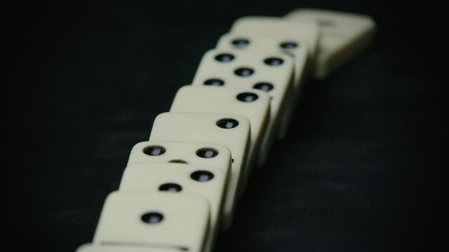 Shooting of falling domino elements - domino effect on black
