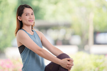 Young beautiful Asian woman in sports outfits doing stretching before workouts at hot during COVID-19 pandemic to keep a healthy life. Healthy young woman stretching and warming up to workouts