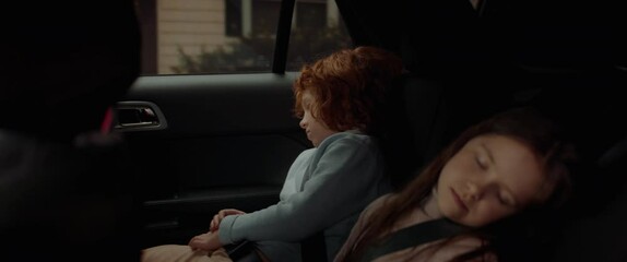 Cute little siblings sleeping on a back seat of a modern SUV while riding through neighborhood. Shot with 2x anamorphic lens - Powered by Adobe
