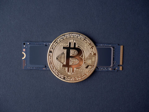 bitcoin on an ssd m2 disk on a black background. The concept of cryptocurrency mining on ssd hhd disks