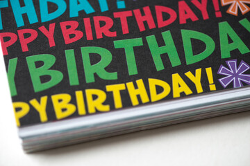 scrapbooking paper, featuring repetitive birthday greetings (happy birthday) in various colours on black