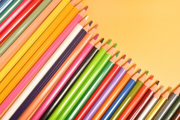 Colored pencils close-up on a yellow background