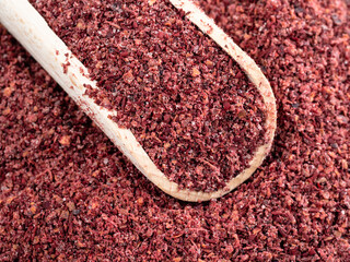 scoop on pile of sumac powder closeup