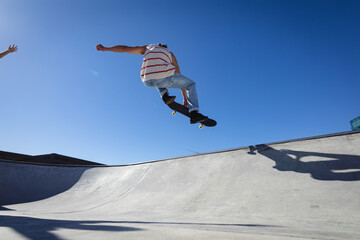 Caucasian man jumping and skateboarding on sunny day
