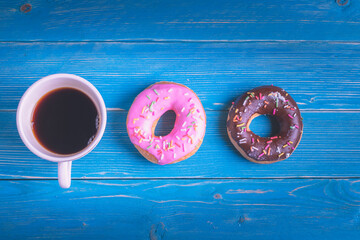 back coffee and sweet donuts on blue wood table