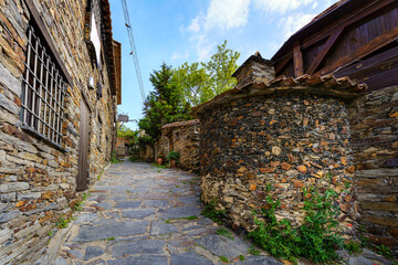 Old town alley with stone houses and old stone wood-fired oven. Patones de Arriba Madrid.