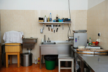 In the kitchen: butcher's knives, blender, sink, cutting desk and other kitchen utensils
