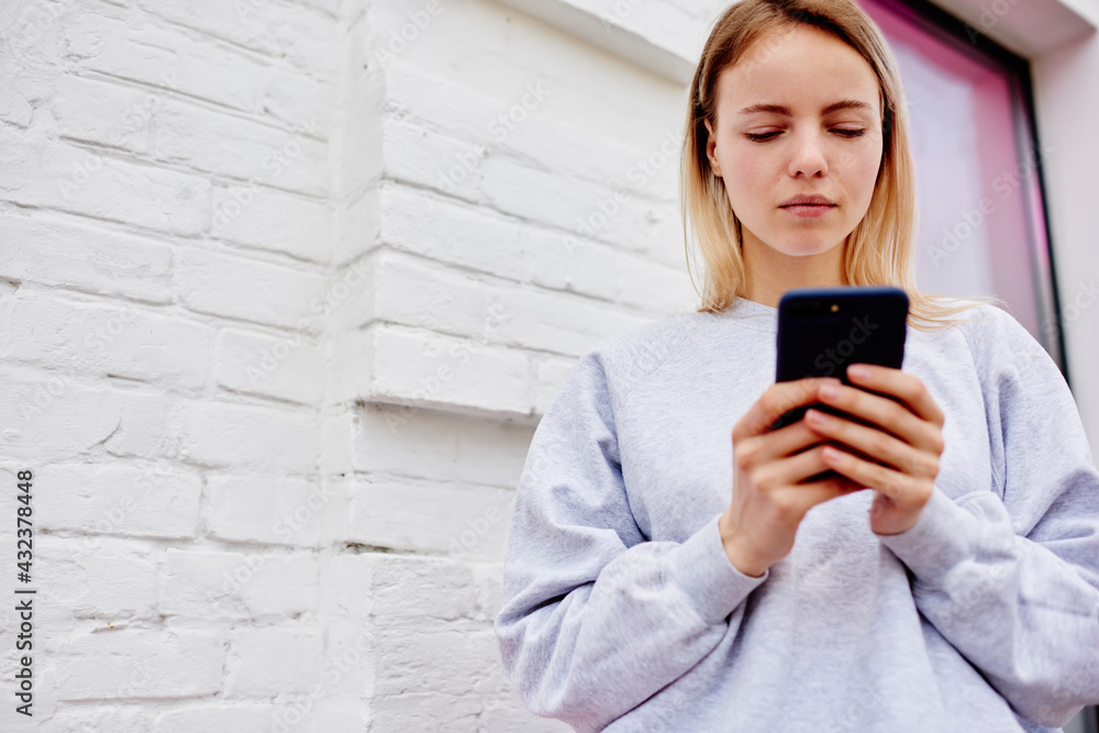 Poster caucasian hipster girl writing message for sending sms via mobile application using 4g wireless inte