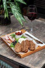 Wine and snack set. Flat-lay of wineglasses and cheese and appetizers board over concrete background, top view. Party food concept, cafe.