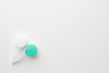Container for storing contact lenses, tweezers on a white background