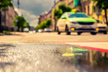 Sunny day after rain in the city, road with markings on which the car rides. Close up view from the...