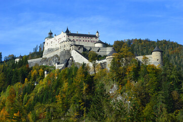 Fototapeta na wymiar Hohenwerfen Castle, Salzach Valley Austria. The huge imposing fortress sits above a hill, surrounded by trees and is a popular tourist attraction.