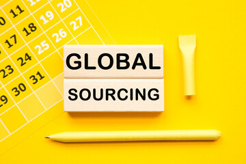 GLOBAL SOURCING. calendar and WOODEN BARS with informationon on the a yellow background desktop .