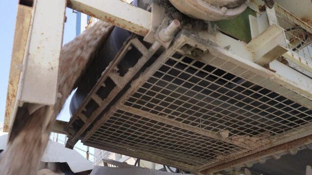Low angle close-up of concrete going into the mixer car.