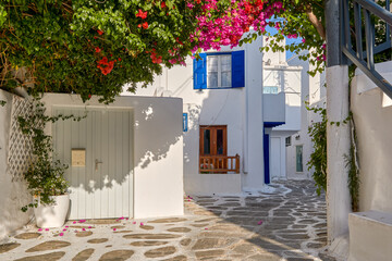 Beautiful traditional streets of Greek island towns. Whitewashed houses, rich bougainvillea in...