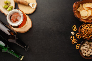 bottle of beer and different snacks on rustic wooden table. Top view