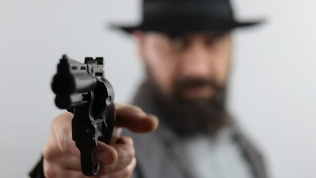 Bandit, gangster or detective pointing gun at camera, isolated on white background.