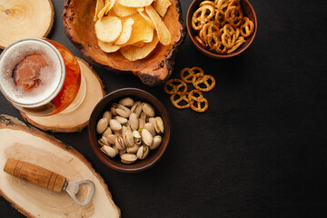 bottle of beer and different snacks on rustic wooden table. Top view