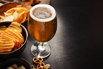 bottle of beer and different snacks on rustic wooden table. Top view
