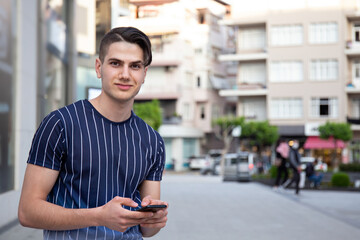 Portrait of young handsome man of Arabic ethnicity on the city streets. Iranian guy over with hipster hairstyle wearing casual attire. Close up, copy space for text.